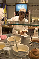 Server pours clam chowder into a bread bowl at Boston Chowda, Quincy Market, Boston, MA
