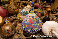 A colorfully beaded gourd rests among a mountain of painted and plain vessels at the Mexican Folk Art Museum in Cancun.