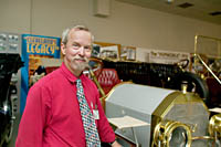 Allan J. Unrein, Director of the Crawford Auto-Aviation Museum with the 1909 Simplex he drove in a mock race with a biplane in the Cleveland Air Show.  The simplex was clocked at 91 miles per hour.