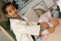 A young girl in a lab coat administers a shot to a doll in the Maroma section of Trompo Magico Interactive Museum.