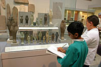 Two boys sketch Egyptian artifacts for a school assignment at the British Museum in London.