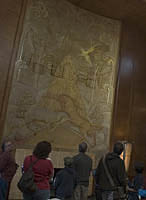 Tour guide Joe Goff describes the gesso panel  Unicorns in Battle by Alfred J. Oakley and Gilbert Bayes in the Queen's Salon on the RMS Queen Mary.