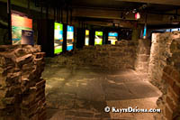 Artifacts are displayed in cases with colored panels among the walls of early Montreal buildings. Š Kayte Deioma