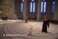 People walk in meditation on the indoor wool tapestry labyrinth at Grace Cathedral in San Francisco, CA.