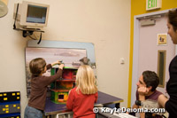 Two kids position their clay figures on a background while mom operates the stop-motion video camera at the Zeum in San Francisco.